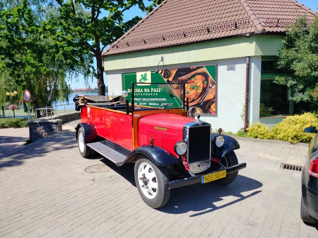 Zdjęcie klasycznego auta na tle restauracji Kaczka na fali