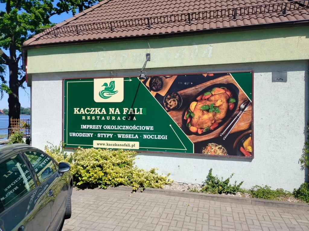 Zdjęcie restauracji z zewnątrz, na głównym planie widać nowy banner Kaczki na fali
